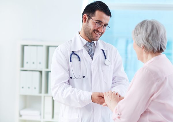 Confident doctor looking at his senior patient while speaking to her